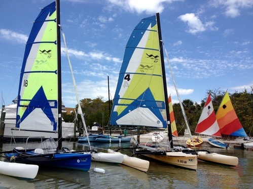 Trimarans and Sunfish Sailboats in a row